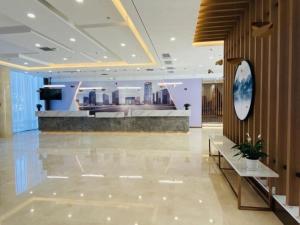 un vestíbulo de un hotel con un reloj en la pared en Green Tree Inn Tianjin Dongli District Airport Free Trade Zone, en Guanjiazhuang