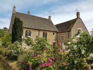 an old stone house with flowers in front of it at Prebendal Manor in Nassington