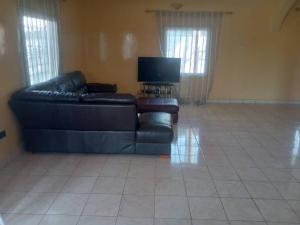 a living room with a couch and a tv at Costal Road Hideout in Serekunda