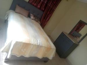 1 dormitorio con 1 cama grande y cabecero azul en Costal Road Hideout, en Brufut