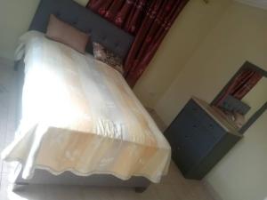 a bedroom with a large bed with a blue headboard at Costal Road Hideout in Brufut