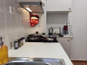 eine Küche mit Töpfen und Pfannen auf einem Herd in der Unterkunft Smart cozy apartment in Athens! in Athen + 6 Fotos
