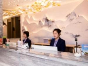 duas pessoas sentadas num balcão num restaurante em VX Hotel Shangrao High-Speed Railway Station em Shangrao