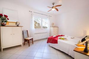sypialnia z łóżkiem i wentylatorem sufitowym w obiekcie Villa Helios - PlusHolidays w mieście Calpe