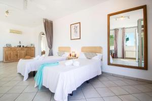pokój hotelowy z dwoma łóżkami i lustrem w obiekcie Villa Helios - PlusHolidays w mieście Calpe