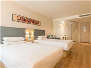מיטה או מיטות בחדר ב-Hanting Hotel Hohhot Manduhai Park