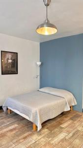 Bett in einem Schlafzimmer mit blauer Wand in der Unterkunft Monroe's studio at the heart of Cannes and beaches in Cannes