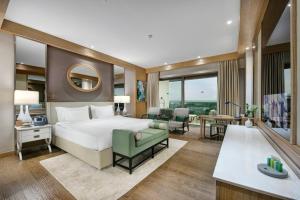 um quarto com uma cama grande e uma sala de estar em Regnum Carya em Belek