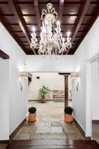 Habitación grande con una lámpara de araña colgando del techo. en Hotel Mercader de Sedas en Granada