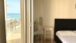 a bedroom with a bed and a balcony with the ocean at Trilocale centro Marcelli fronte mare - M223 in Marcelli