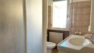 a bathroom with a sink and a toilet and a window at Trilocale centro Marcelli fronte mare - M223 in Marcelli +13 photos
