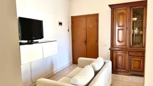 ein Wohnzimmer mit einem Sofa und einem Flachbild-TV in der Unterkunft Trilocale centro Marcelli fronte mare - M223 in Marcelli