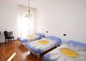 Cette chambre comprend 2 lits avec des fleurs. dans l'établissement Ampio appartamento 8 POSTI LETTO, à Rapallo