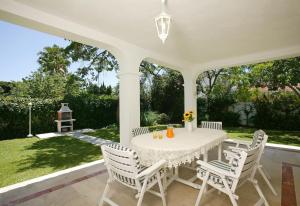 a white table and chairs on a patio at Beautiful Villa La Caracola in Marbella