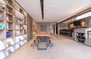 a library with a table and chairs and shelves at Hanting Hotel Suqian Powerlong Plaza in Suqian