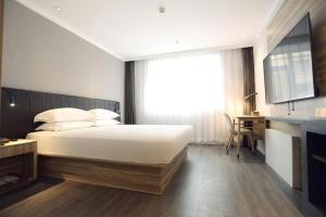 En eller flere senger på et rom på Hanting Premium Hotel Changchun Xintiandi Shopping Park