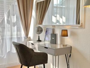 einen Glasschreibtisch mit einem Stuhl und einer Lampe in der Unterkunft Boutique Apartment • Zentrum • Netflix • Parkplatz in Bad Schandau