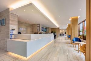 an office lobby with a reception counter and chairs at Hanting Premium Hotel Xiamen SM Plaza Songbo in Jiangtouzhen