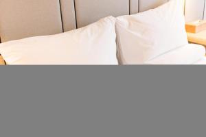 two beds with white sheets and pillows at Ji Hotel- Putian Phoenix Mountain Park in Putian