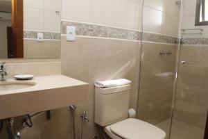 a bathroom with a toilet and a sink and a shower at Hotel Areias Brancas in Rosário do Sul +18 photos