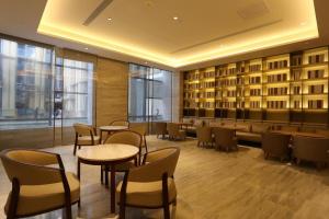 a restaurant with tables and chairs in a building at Ji Hotel Yinchuan Guangyao Center in Yinchuan
