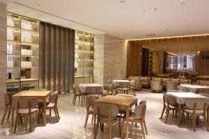a restaurant with tables and chairs and a bar at Ji Hotel Yinchuan Guangyao Center in Yinchuan