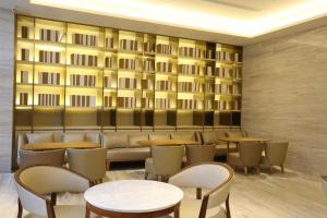 a restaurant with tables and chairs and a wall at Ji Hotel Yinchuan Guangyao Center in Yinchuan