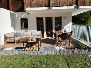 a patio with a couch and a table and chairs at Vieux Valais EG Ost in Bellwald