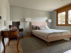 a bedroom with a bed and a table and a chair at Vieux Valais EG Ost in Bellwald