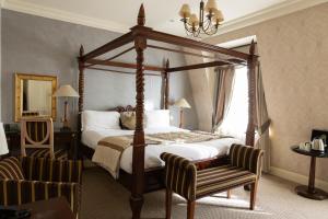 um quarto com uma cama de dossel e uma cadeira em The Leonard Hotel em Londres