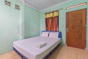 Villa Sari Intan Ciater RedPartner في سوبانج: غرفة نوم بسرير وملاءات بيضاء وباب