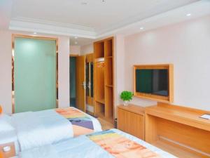 1 dormitorio con 2 camas y TV de pantalla plana en Shell Hotel Wuhu Jiujiang District Daqiao Town Huashan Road en Wanli