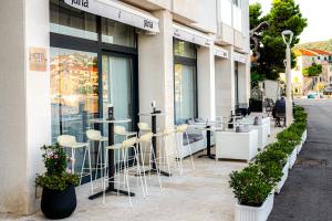 een café met krukken voor een gebouw bij Hotel Vrilo - Adults Only in Postira