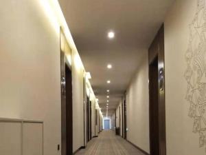 um corredor de um edifício com um longo corredor em GEM Hotel Zibo Economic Development Zone Zibo Vocational Institute em Jinan