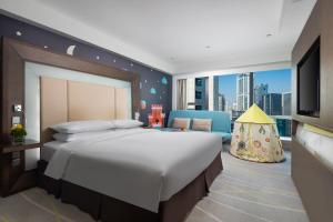 sypialnia z dużym łóżkiem i telewizorem w obiekcie Novotel Nanjing Central w mieście Nankin