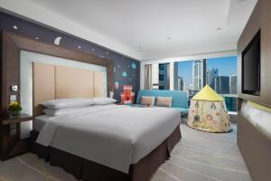 um quarto com uma cama grande e uma televisão em Novotel Nanjing Central em Nanquim