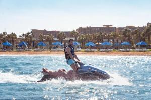 a man riding on the back of an elephant in the water at Grand Ocean Sokhna Hotel in Ain Sokhna