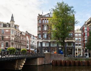 een brug over een rivier in een stad met gebouwen bij Dikker & Thijs Hotel in Amsterdam