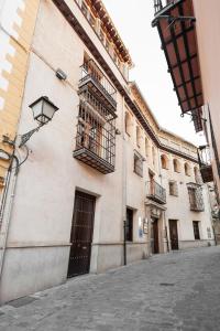 - Edificio con puerta y balcón en Hotel Mercader de Sedas, en Granada