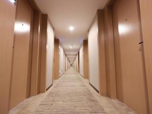 a long corridor with a long hallway at GreenTree Inn Express Jiangsu Suqian School Yingmadi Road in Suqian