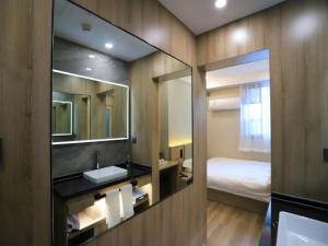 a bathroom with a sink and a mirror at VX Hotel Jiangsu Taizhou Xinghua RT-Mart in Xinghua