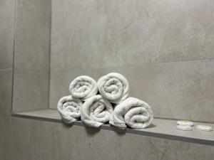a pile of rolled towels on a shelf in a bathroom at Vila Drina Apartments in Banja Koviljača +60 photos