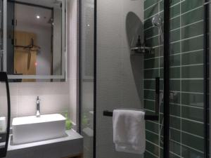 W łazience znajduje się umywalka oraz prysznic z lustrem. w obiekcie GreenTree Inn Express Datong High-Speed Railway Station Old City Wall w mieście Datong