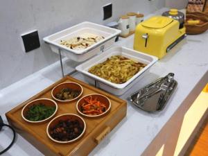 un mostrador con varios tazones de comida. en GreenTree Inn Luoyang Railway Station Wangfujing Wangcheng Park, en Luoyang