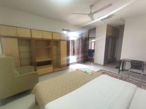 een slaapkamer met een groot bed en een stoel bij Individual Home 4 BR at Sector 7 HSR Layout in Bangalore