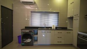 eine Küche mit Geschirrspüler und Spüle in der Unterkunft Kris Apartment in Ibadan