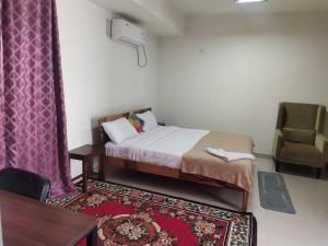 een kleine slaapkamer met een bed en een stoel bij Individual Home 4 BR at Sector 7 HSR Layout in Bangalore