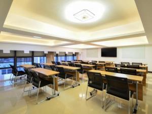 un aula vacía con mesas, sillas y una pantalla en VX Hotel Hubei Wuhan Moshui Lake National Expo Yongwang en Hanyang