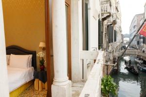 ヴェネツィアにあるホテル コロンビーナのベッド付きの客室で、運河の景色を望めます。