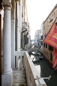 a person holding a flag next to a canal at Hotel Colombina in Venice